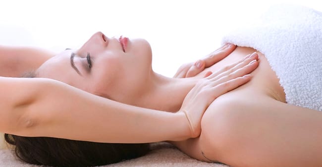 Hands massaging breasts to promote circulation and collagen growth